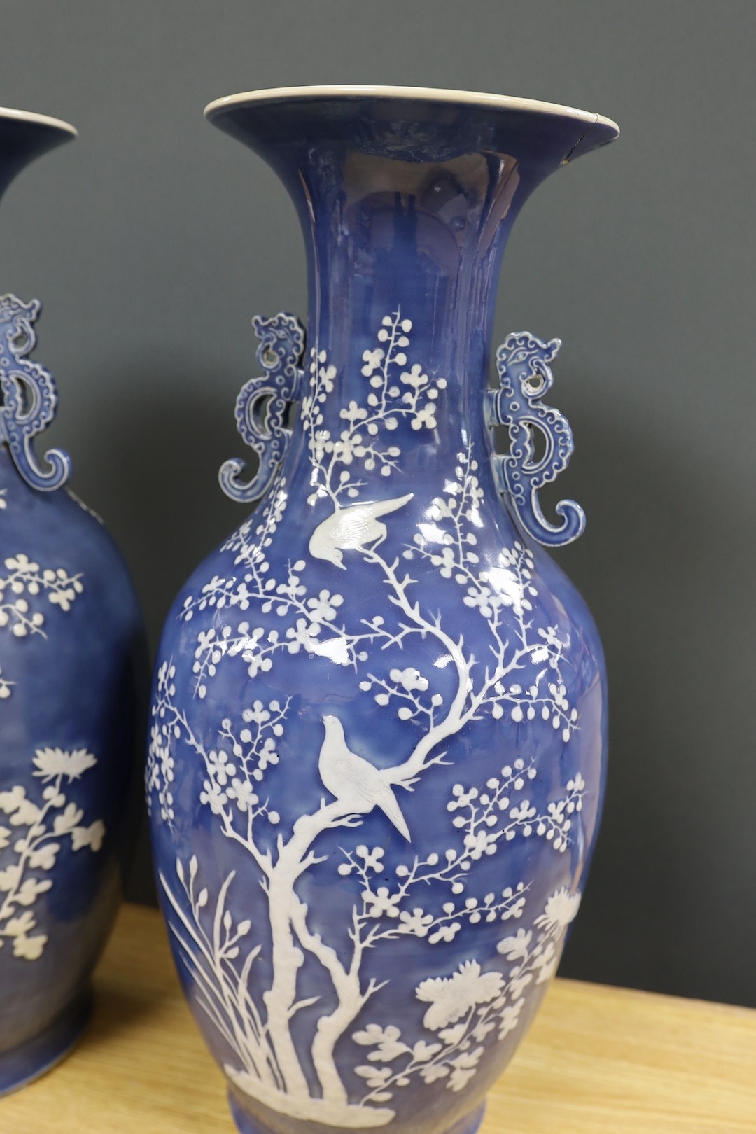 A pair of large 19th century Chinese slip decorated blue ground vases, restored, 59cm